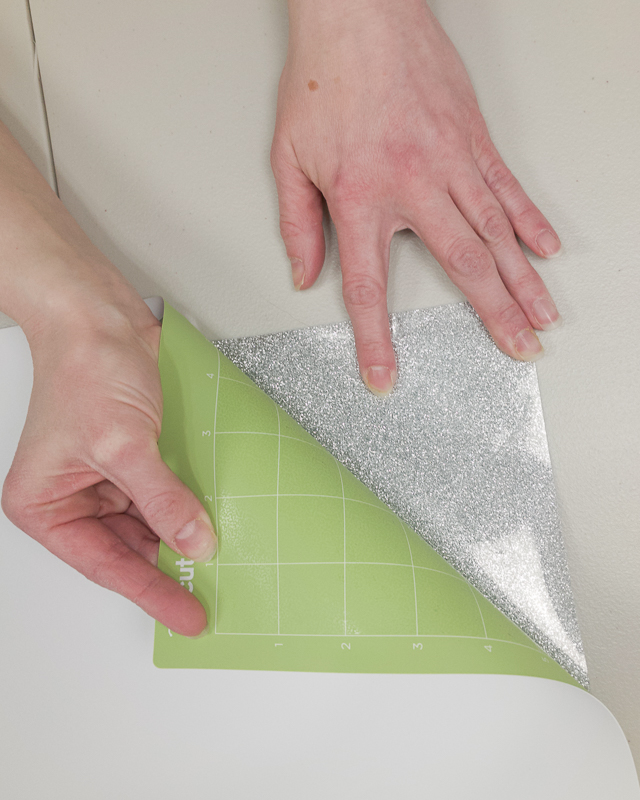 Place one hand on your glitter iron on and then pull the Cricut mat away from the material to remove it from the mat