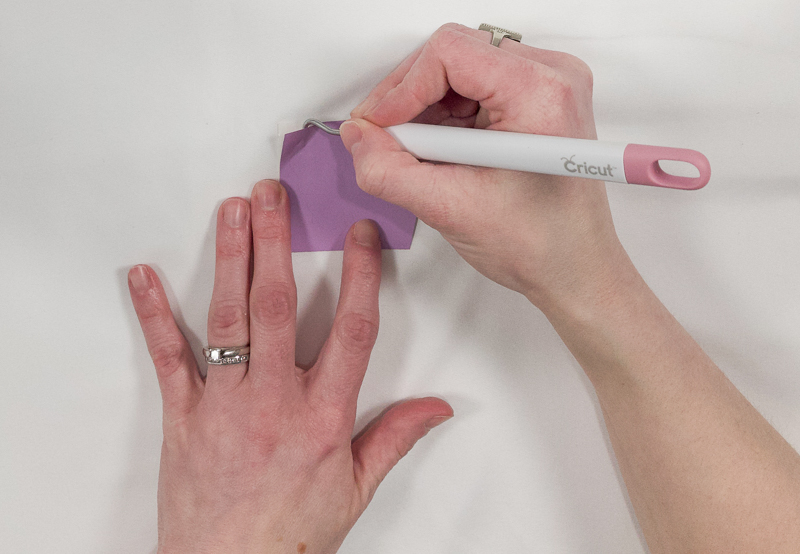 Insert weeding tool into the top corner of your design and gently lift up the adhesive vinyl